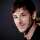 French actor Gaspard Ulliel, in a simple black long-sleeved shirt, smiles at the press.
